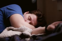 woman in blue shirt lying on bed