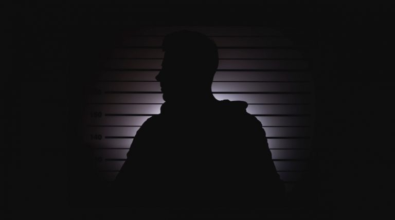 silhouette-of-unknown-man-in-mugshot-or-police-lineup-background