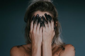 woman covering face with both hands closeup photography