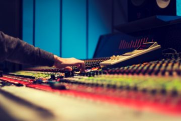 closeup photography of man operating audio mixer