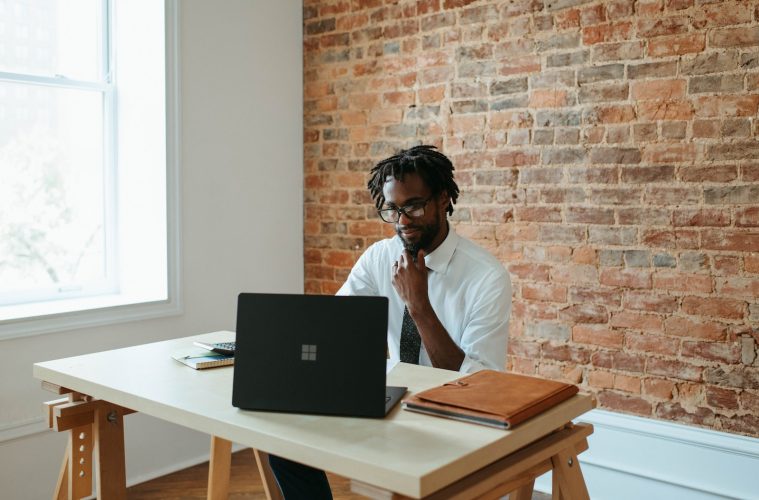 a man sitting at a table in front of a laptop