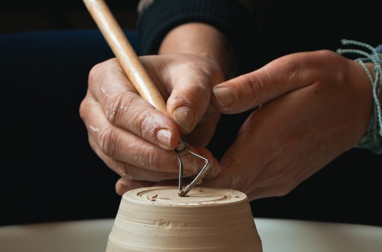person holding white plastic cup with brown liquid