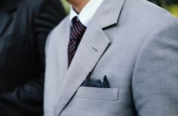 man wearing gray notched lapel suit jacket standing