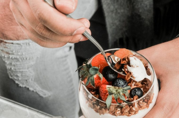 a person eating a bowl of fruit