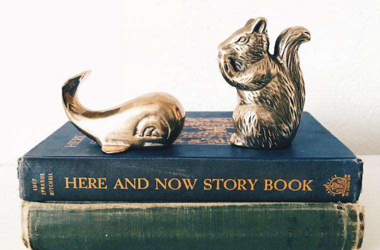 gray and white rabbit figurine on green book