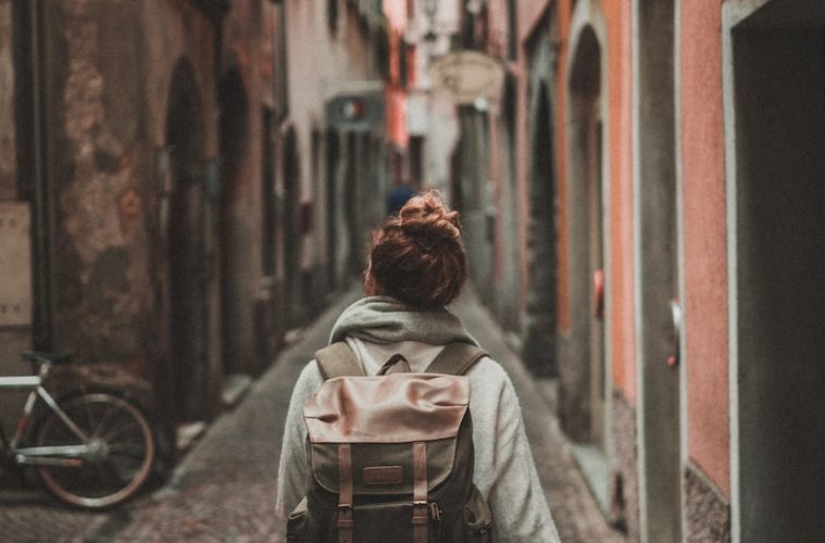 woman walking on street surrounded by buildings