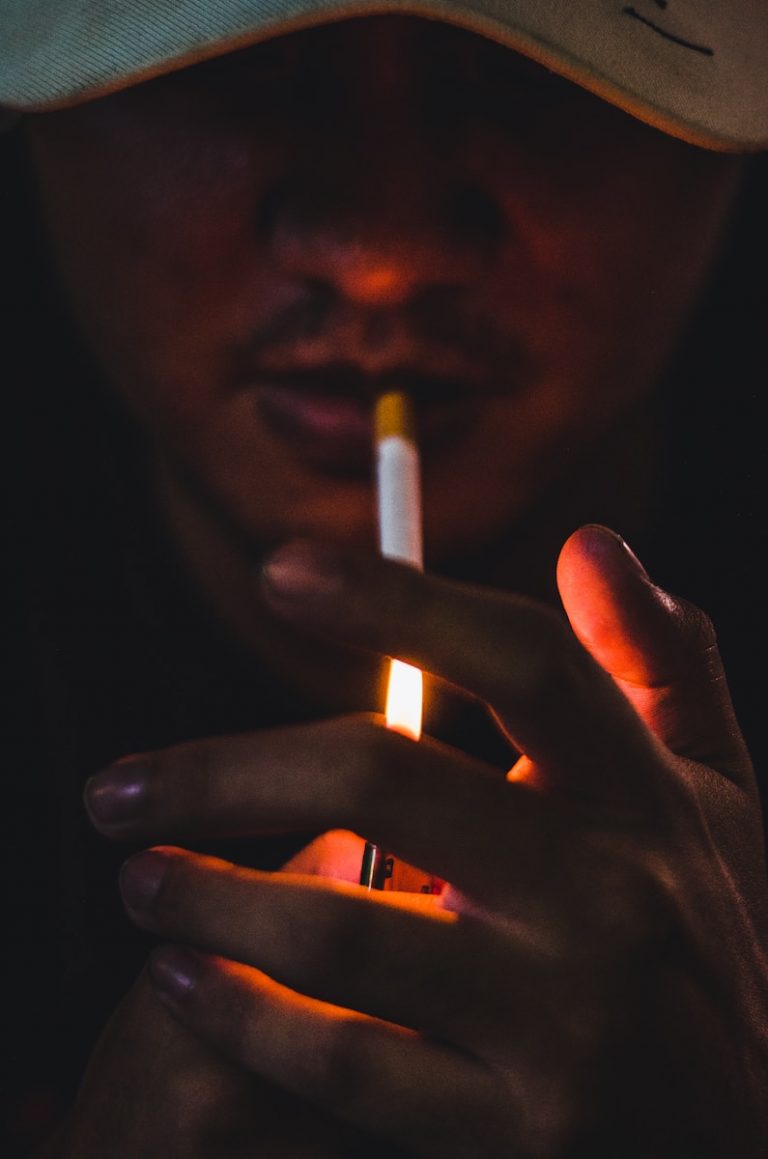 a man holding a lit cigarette in his hand