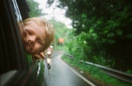 child peeking from vehicle window