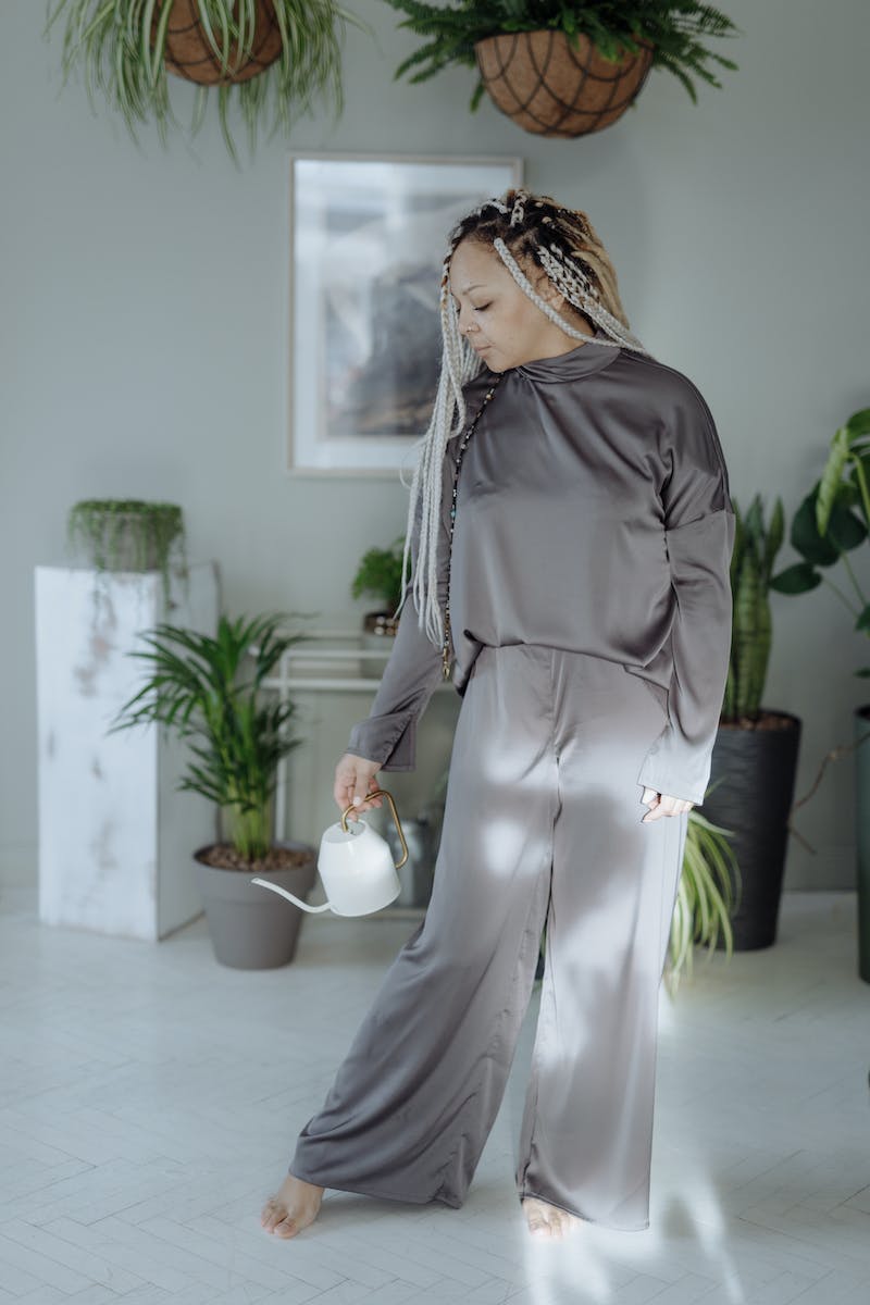 A Woman in Gray Co-Ords Holding a Teapot
