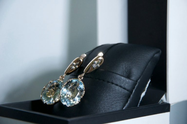 a pair of earrings sitting on top of a black case